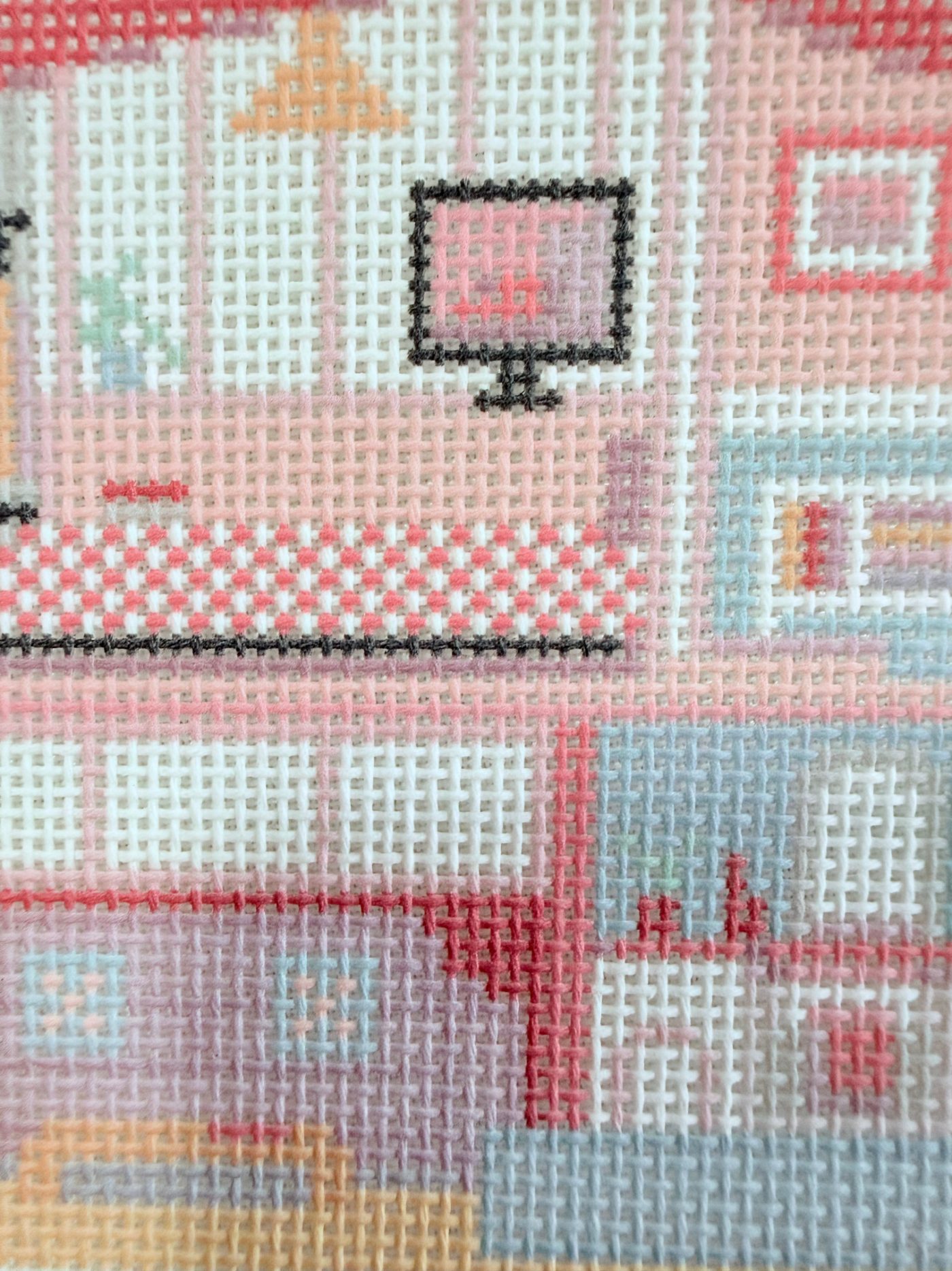 Close-up of the top floor — TV and checkered bed, stitched intersections visible
